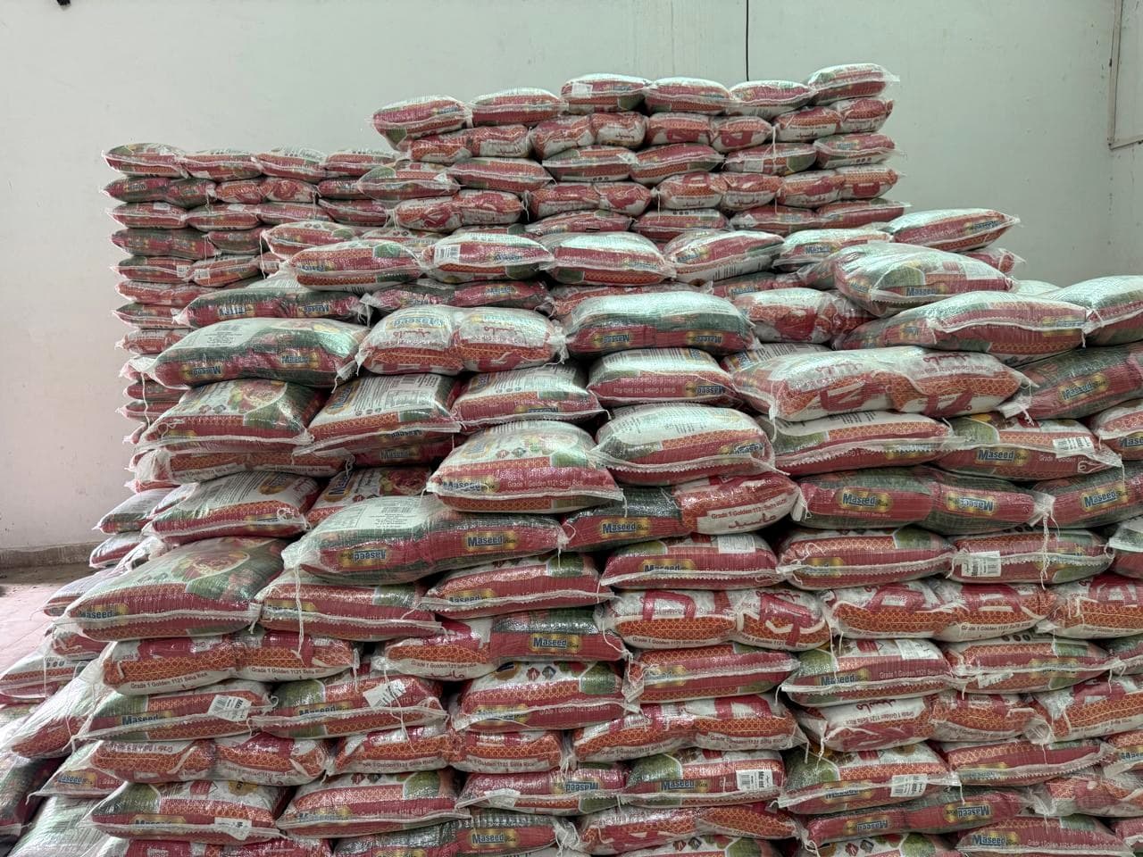 A large stack of rice bags in a warehouse.